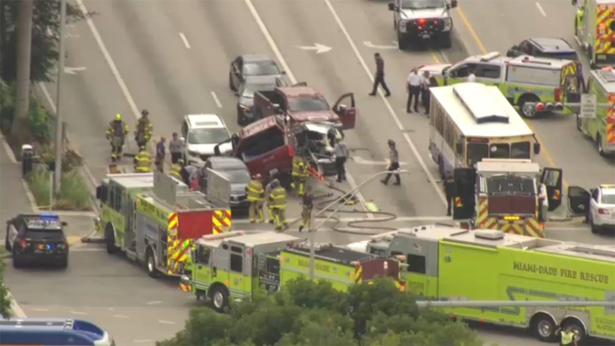 vista aérea de un choque de varios vehículos en NW 36 y 87 en Doral con una GMC roja sobre un carro aplastado y Miami-Dade Fire Rescue en la escena (sin rostros de víctimas)